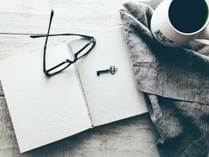 A blank notebook, glasses, and a key