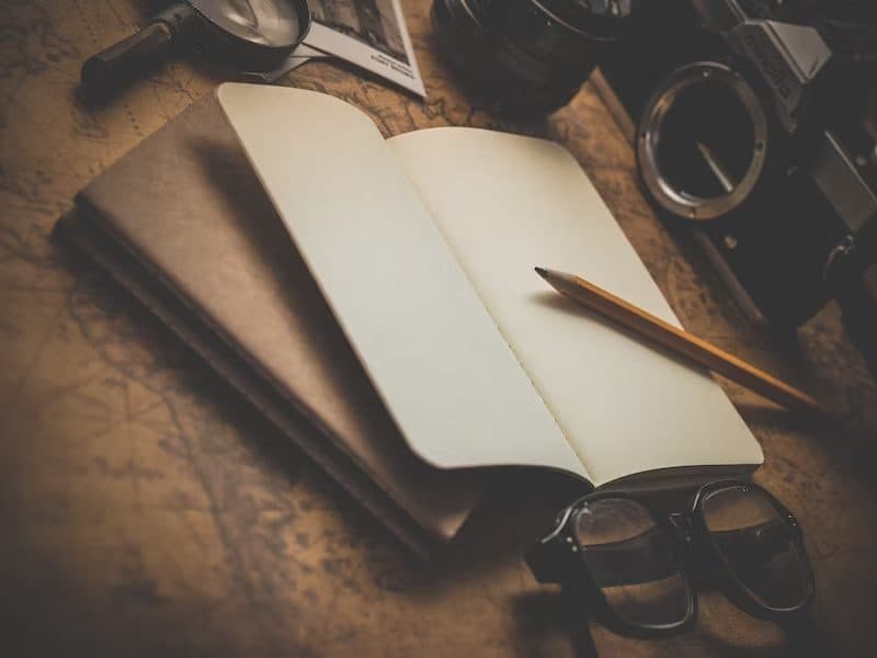 An open notebook and pencil on a vintage map
