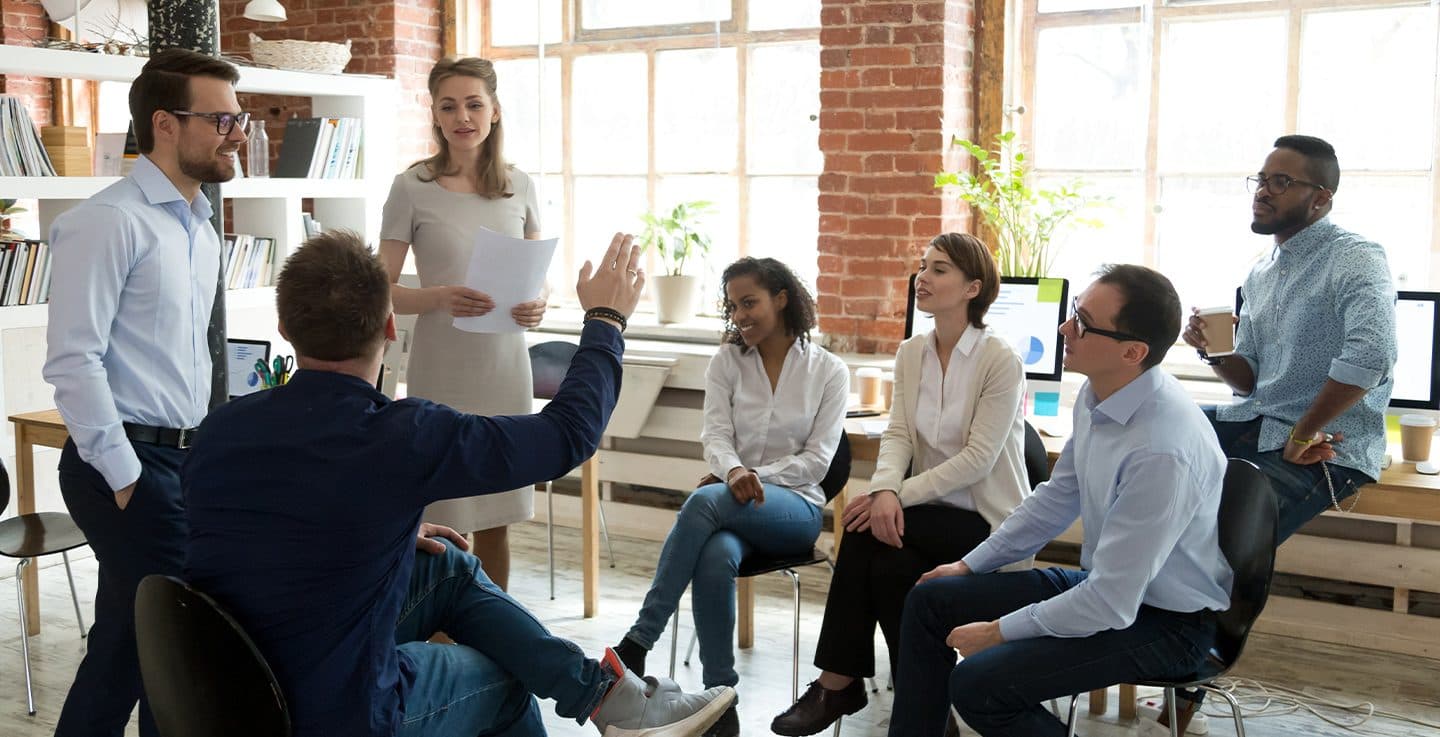 A leadership team standing in a circle in a brick room